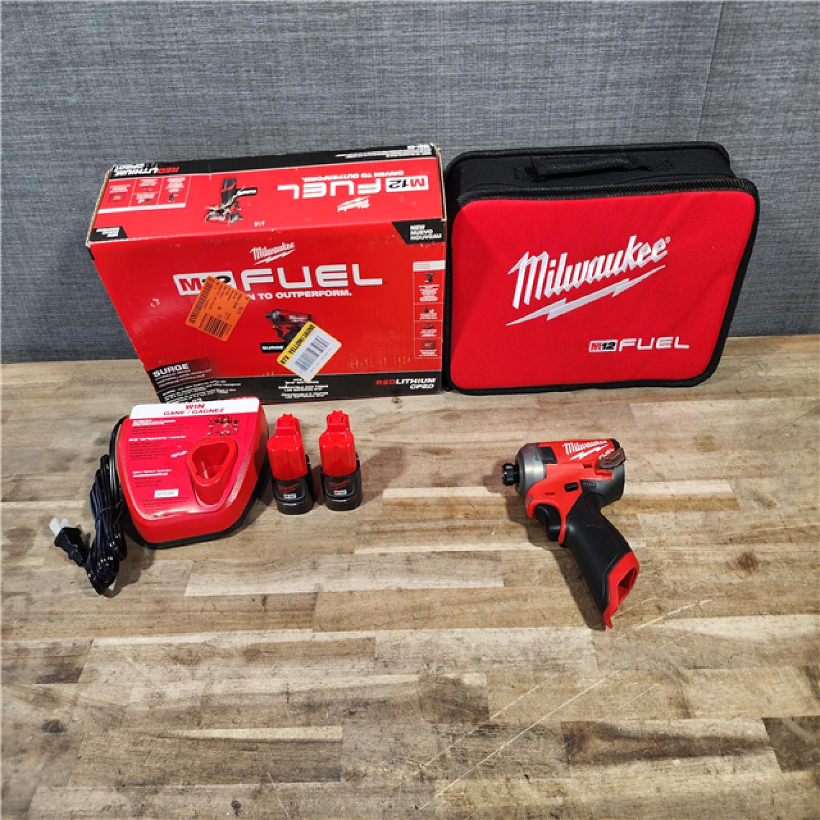 HOUSTON LOCATION - AS-IS (APPEARS LIKE NEW) Milwaukee M12 FUEL SURGE 12V Lithium-Ion Brushless Cordless 1/4 in. Hex Impact Driver Compact Kit W/Two 2.0Ah Batteries  Bag